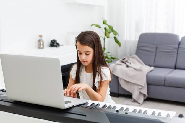 Girl learning how to play a piano online