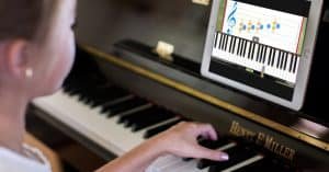 Girl learning how to play piano thru video