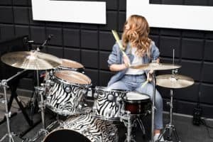 girl playing drums in recording studio