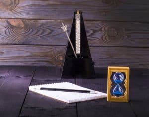 hourglass, metronome and memo pad with a pencil