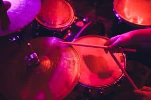 man plays musical percussion instrument with drum sticks