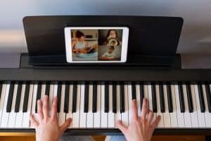 woman having video chat with friends while playing a piano
